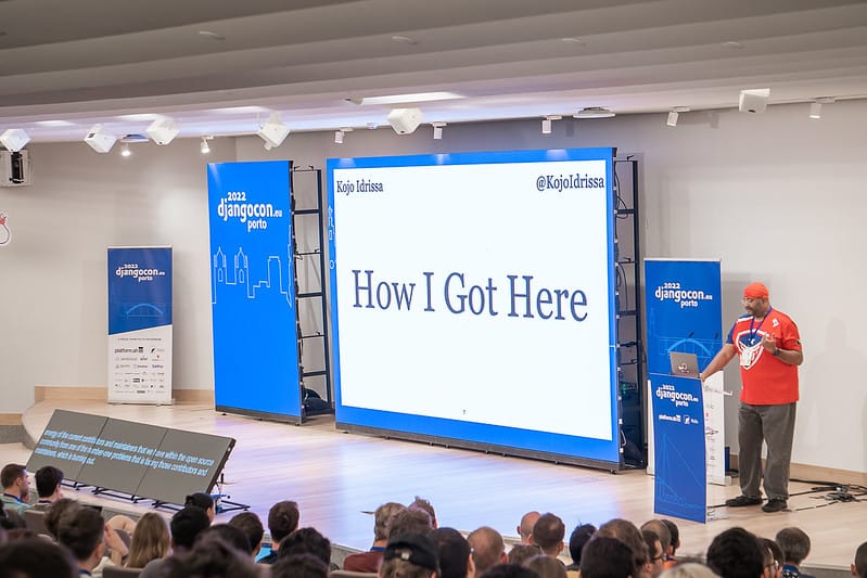 Speaker addressing a crowd at DjangoCon Europe in Porto